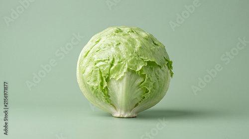 Fresh whole iceberg lettuce head isolated on light green background