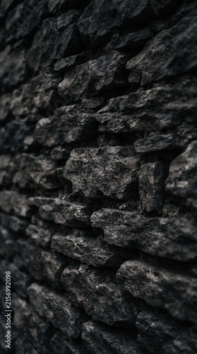 Close-up of rough dark slate stone wall texture with natural cracks and weathered surface detail