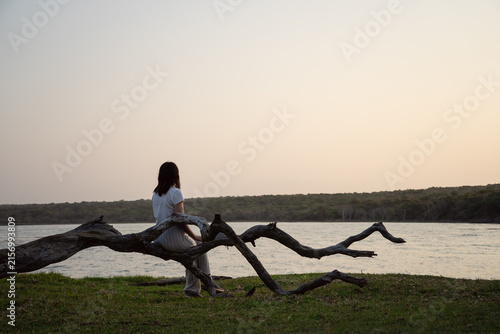 Young woman watching the sunset on the beach
