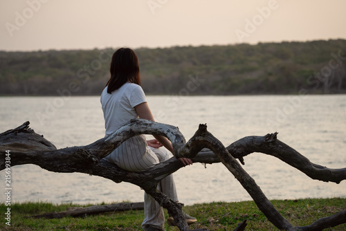 young woman sitting on a tree