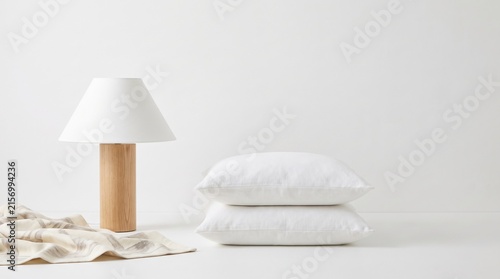 Minimalistic lamp and clean white pillows on a neutral background in a modern setting