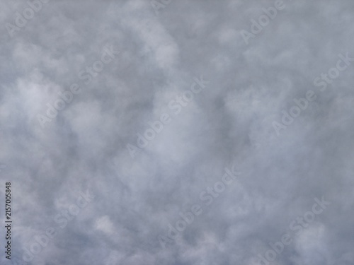Close-up of dense, textured grey and white clouds filling the entire frame, creating a dramatic sky background