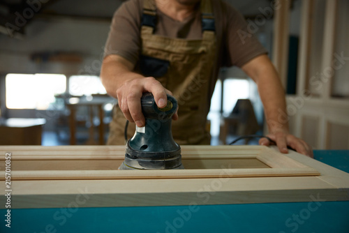 Fotografía Finishing specialist sanding cabinet door surface