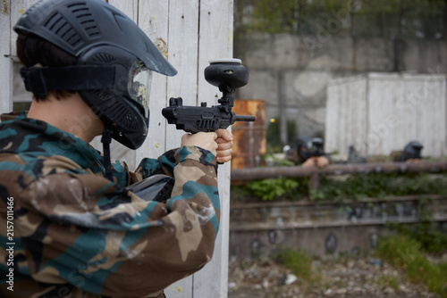 Canvas Print Paintball soldier is taking a defensive position behind the cover during tactica