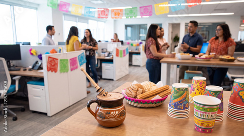 Mexican hot chocolate and colorful cups are on an office desk for Hispanic Heritage Month celebration