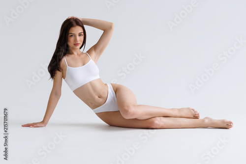Foto Full length young woman with fit body wear lingerie underwear sit with long legs