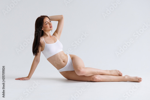 Foto Full length young woman with fit body wear lingerie underwear sit with long legs