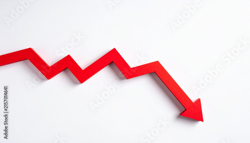 Minimalist business graph with bold red downward arrow descending sharply across white background, simple red line chart, modern financial decline and business risk concept. Close-up.