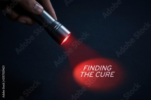 Flashlight beam illuminating finding the cure text in red