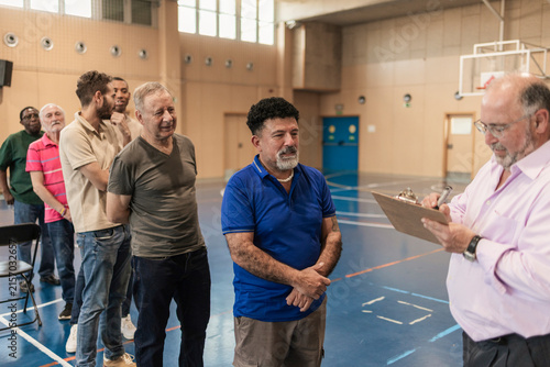 Diverse men registering for community program in gym