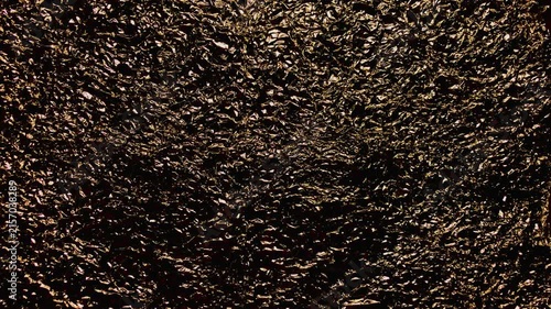 crumpled gold foil texture glittering against deep shadow for luxury branding web design and festive backdrops