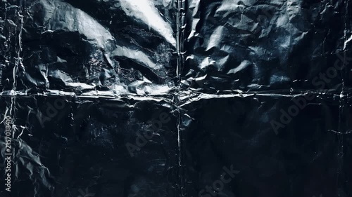 crumpled black foil texture radiating metallic creases evoking moody darkness for web design and advertising backdrop