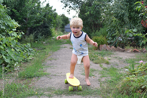 A small child is riding a skateboard lying down.