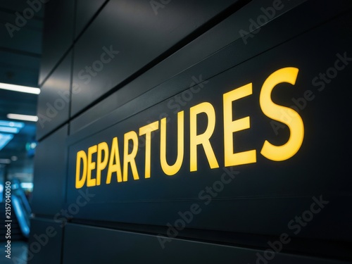 Illuminated departures sign in an airport terminal
