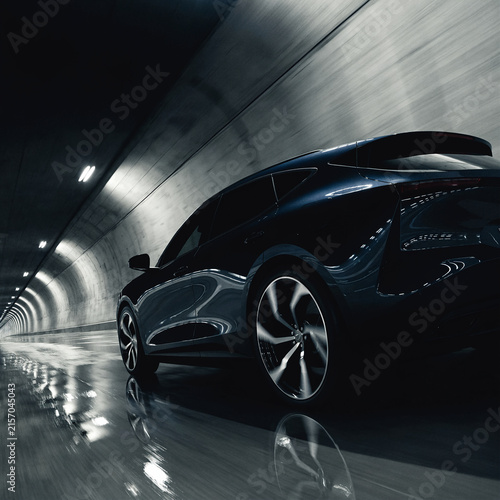 Modern luxury electric car driving fast through a dark illuminated tunnel at night