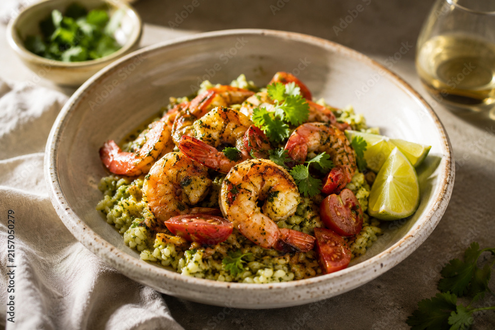 Fototapeta premium Grilled Shrimp with Herb Rice, Tomatoes and Lime in Rustic Ceramic Bowl D