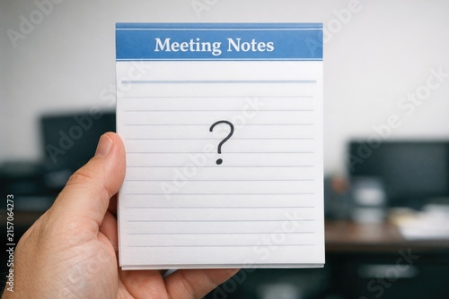 A person holds a notebook with a question mark, ready to jot down thoughts or ideas