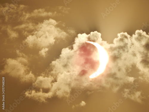 Cuadro en lienzo Éclipse solaire partielle du 12 août 2026 avec le Soleil en forme de croissant traversant les nuages, dans un ciel aux teintes dorées