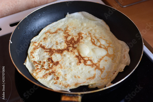 Foto Homemade crepe cooking in frying pan