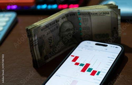 Indian 500 rupees banknotes placed against a stock market chart, symbolising currency, investment, finance and economic growth