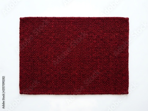 Top view of a textured, deep crimson braided placemat isolated on a white background