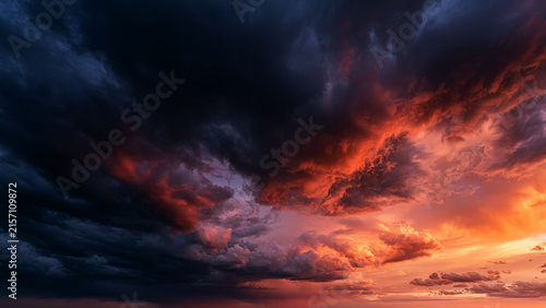 Obraz na płótnie dramatic storm clouds with warm sunset light and dark blue sky
