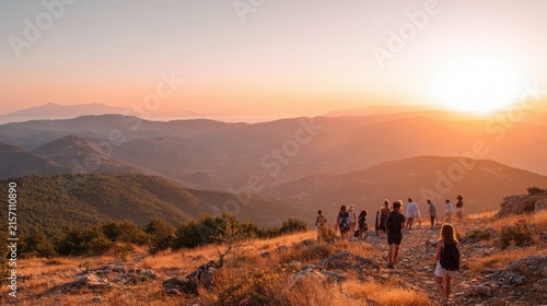 Group hiking on mountain ridge path during golden sunset with group hikers