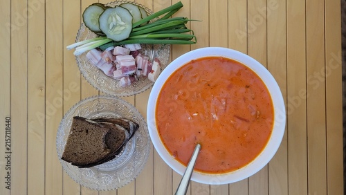 Traditional cold beet soup served with dark bread and fresh vegetables