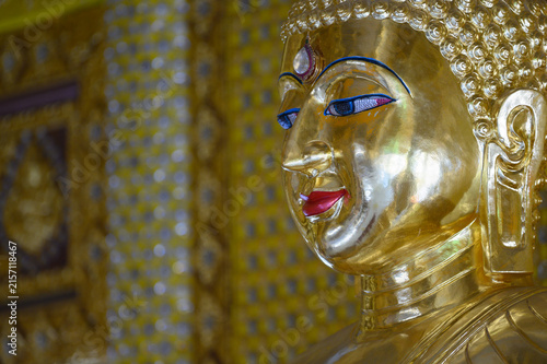 Close Up of Golden Buddha Statue with Ornate Eyes in Thai Temple