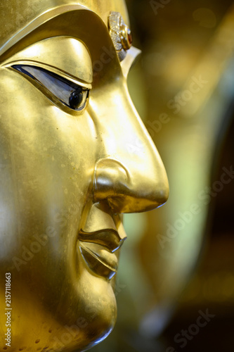 Vertical Close-Up of Golden Buddha Statue Face at Wat San Pa Yang Luang, Lamphun, Thailand