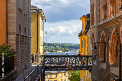 Sticker Stockholm city view with walking people on footbridge