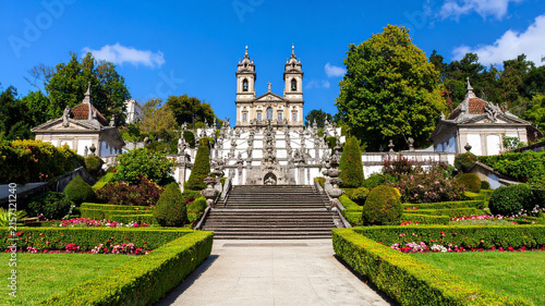 Baroque church and staircase with lush gardens under a bright blue sky
