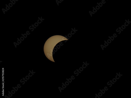 Fotografía A partial solar eclipse appears as a bright golden crescent against a pitch-black sky over Mioglia, Italy