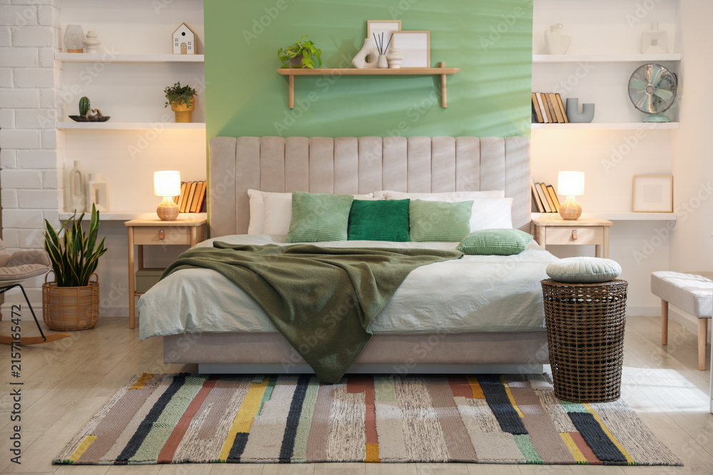 Fototapeta premium Comfortable large bed, other furniture and decor in bedroom. Interior design