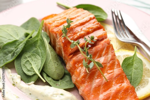Canvastavla Piece of grilled salmon with thyme, basil, lemon and sauce on table, closeup