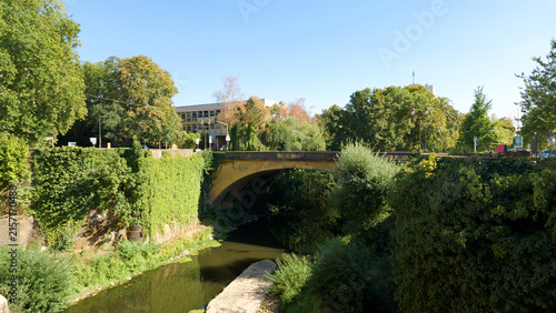 Photography River Moselle flowing under an old stone bridge in Metz, France