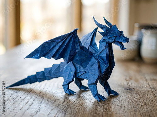 Blue origami dragon paper sculpture on a wooden floor