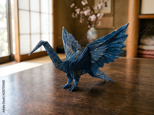 Metal origami crane sculpture on a wooden table