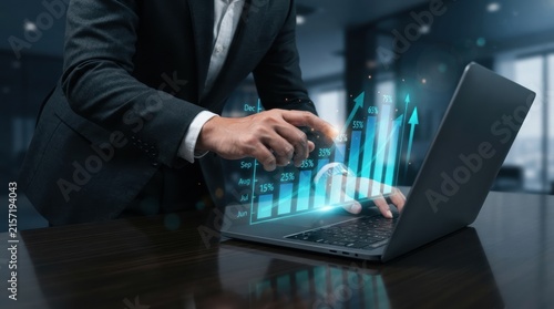 Businessman analyzing holographic growth charts on laptop