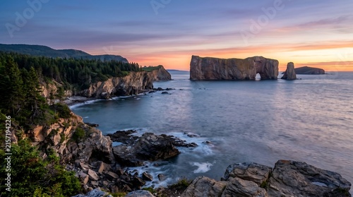 Gaspesie Quebec Perce Rock offshore at sunrise with wild coastline.