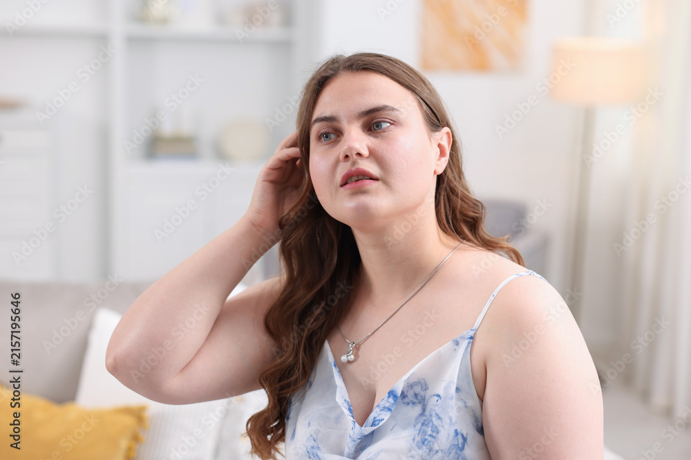 Naklejka premium Young overweight woman at home. Plus size model
