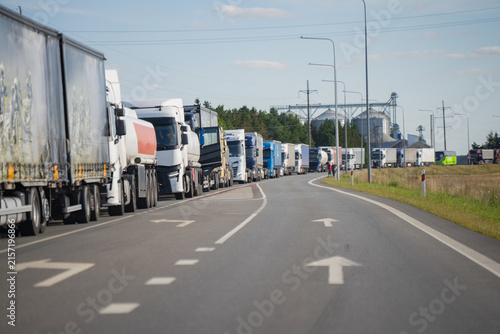 Heavy commercial freight transport trucks queuing in traffic congestion on highway representing cross border trade bottlenecks and freight logistics