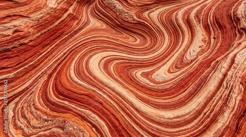 American desert rock striation abstract - swirling red and cream layers.