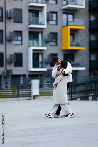 Foto Couple sharing an affectionate hug outdoors near modern city architecture