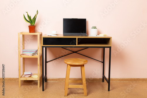 Comfortable workspace with laptop, notebook and flower
