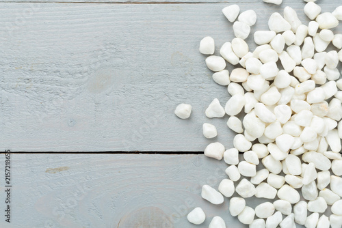 White pebble stones on wooden background, top view