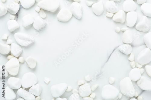 White pebble stones on marble background, top view