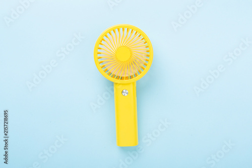 Mini electric fan on color background, top view