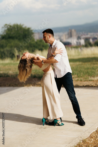 Fotografie Couple dancing outdoors in a romantic dip on sunny day showing connection and jo