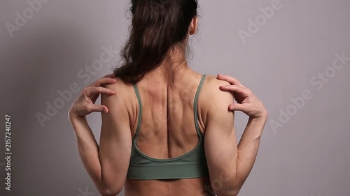 Fit woman performing shoulder and upper back stretches, improving flexibility, mobility, posture and muscle recovery during a fitness and wellness workout in a studio.